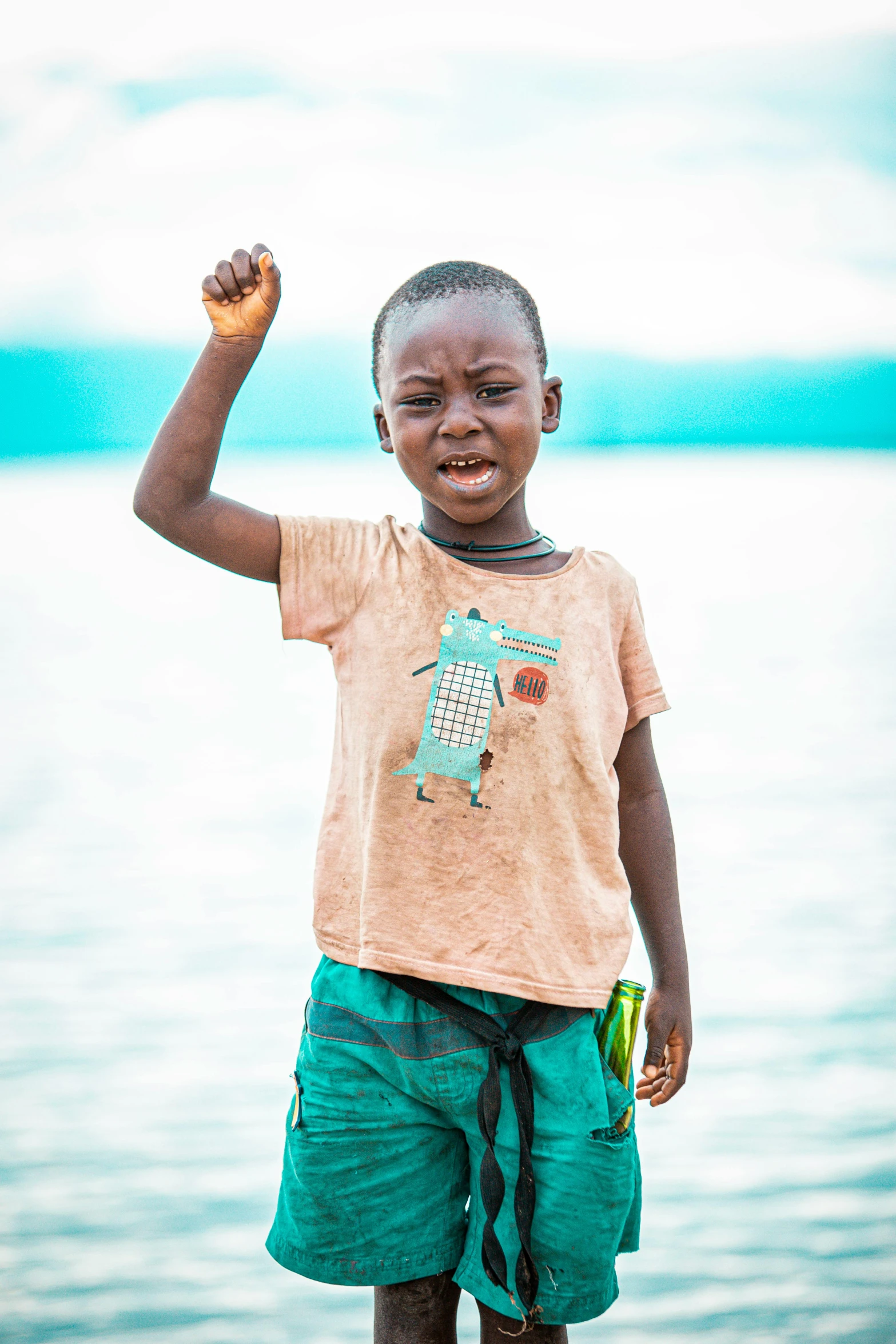 a  holding up his fist on the beach