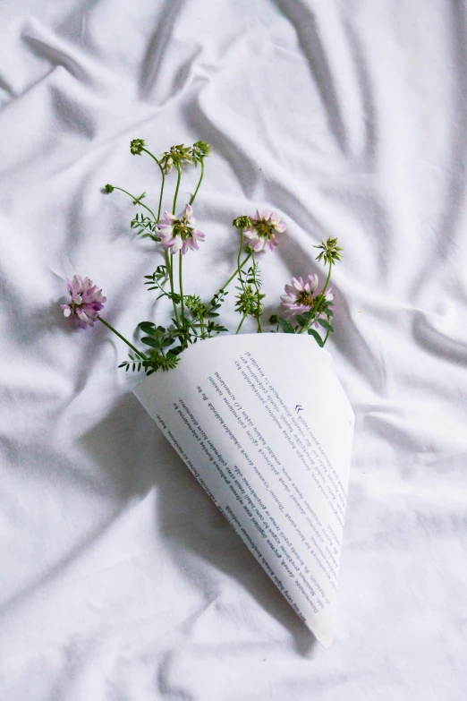 some flowers on a book that is on a white sheet