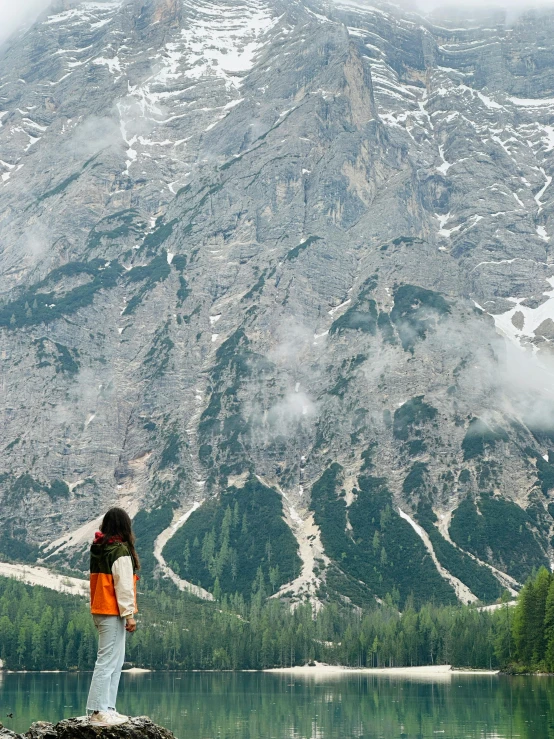 a person standing on rocks at the end of a body of water