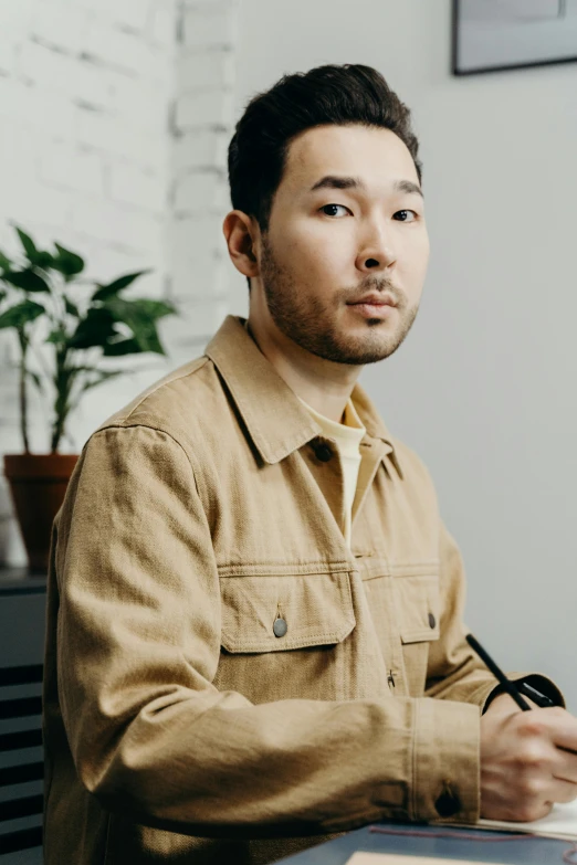 a man sitting at a table with a pen in his hand