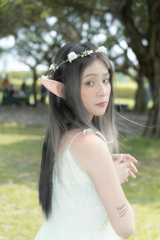 a girl in white dress wearing a flower crown