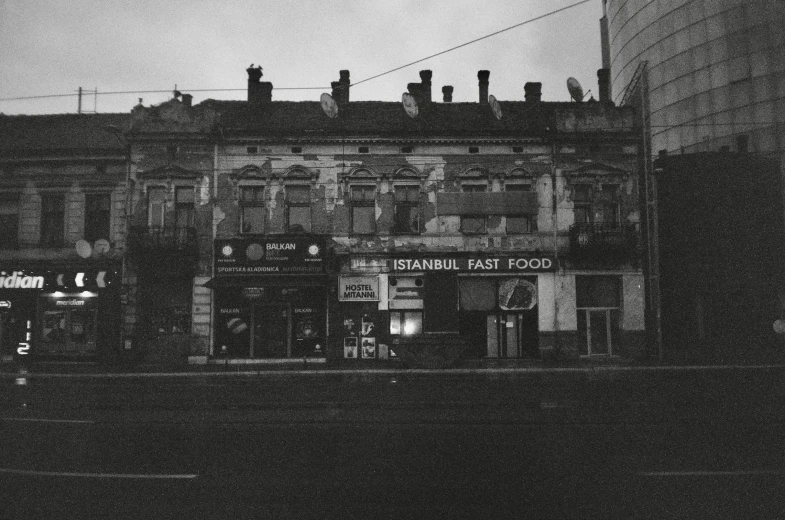 an old building with lots of shop signs in front of it