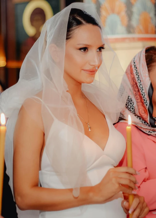 a couple of brides in church with a candle