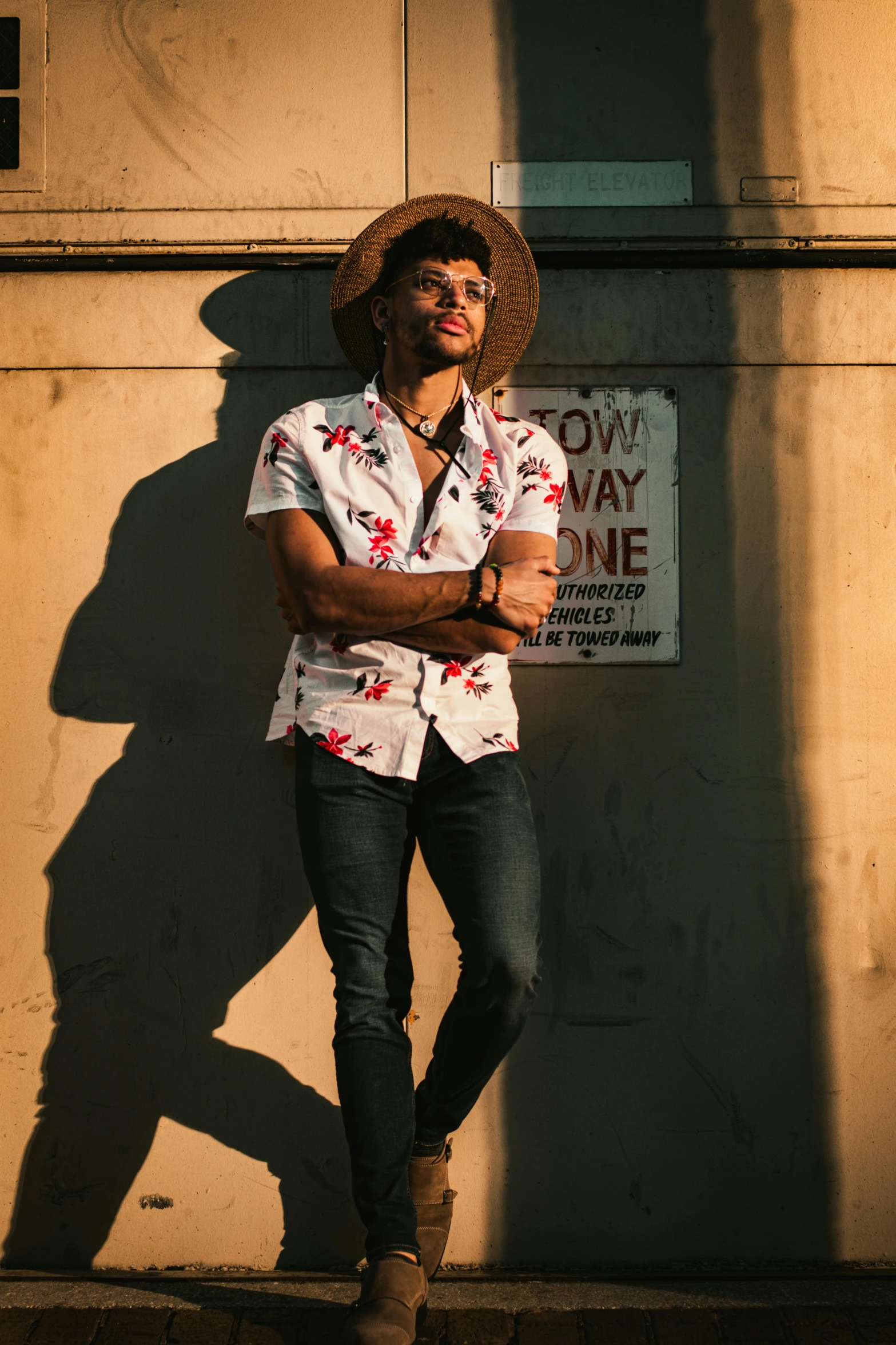 a man with a cowboy hat standing on the sidewalk