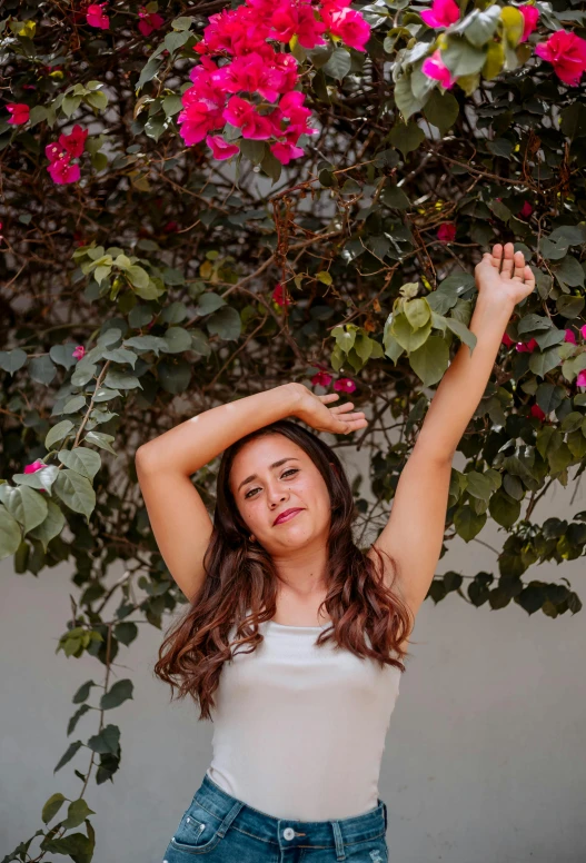 a young woman is standing in front of flowers