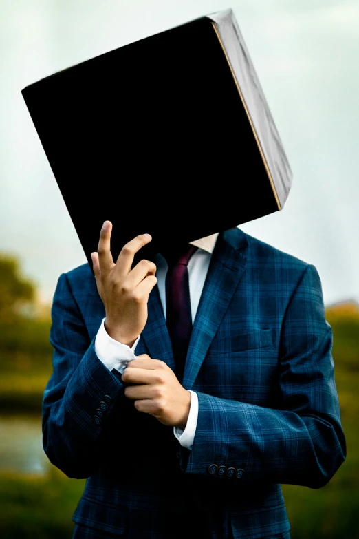 the man is holding a book up to his face