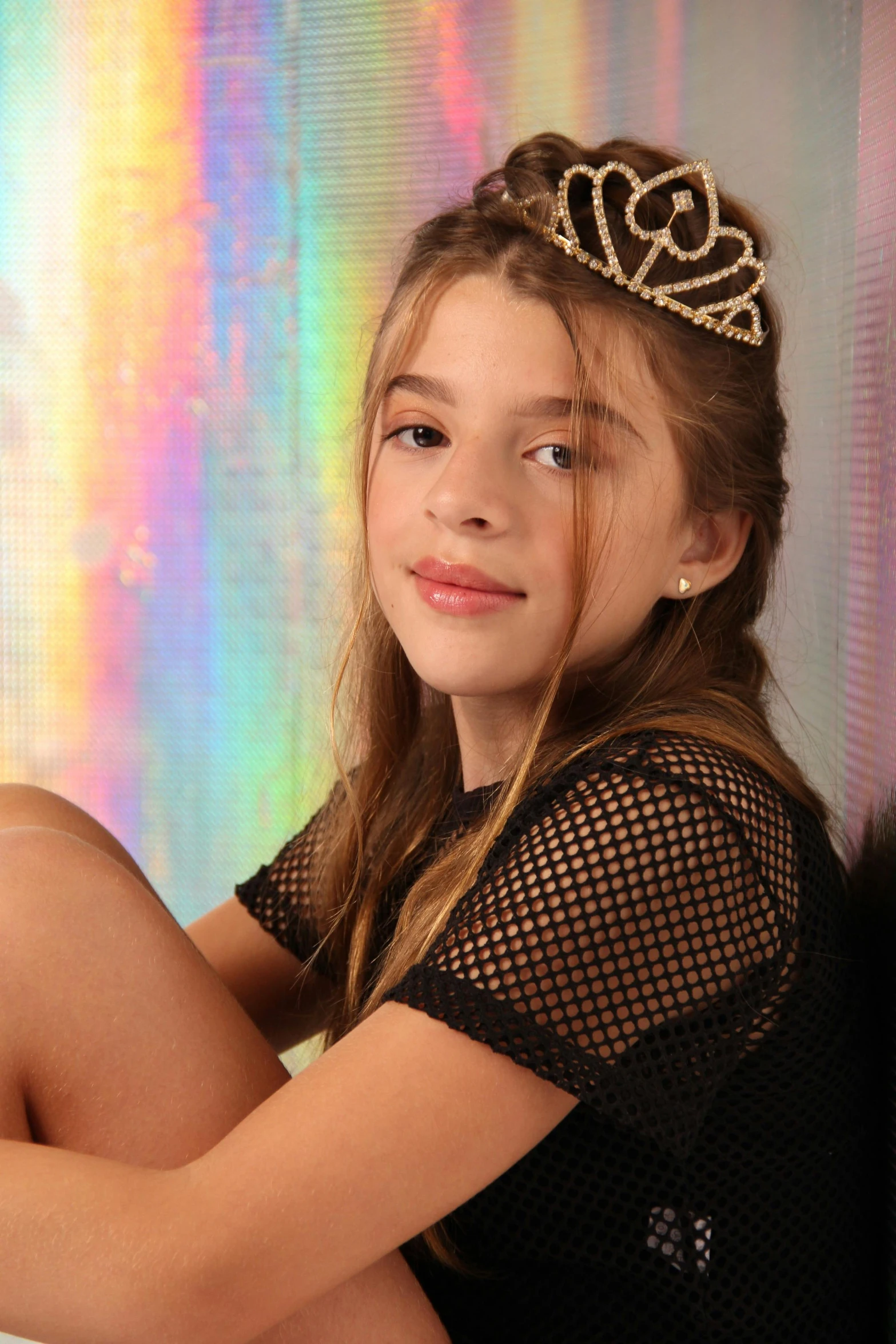 a  sitting on top of a rainbow colored wall