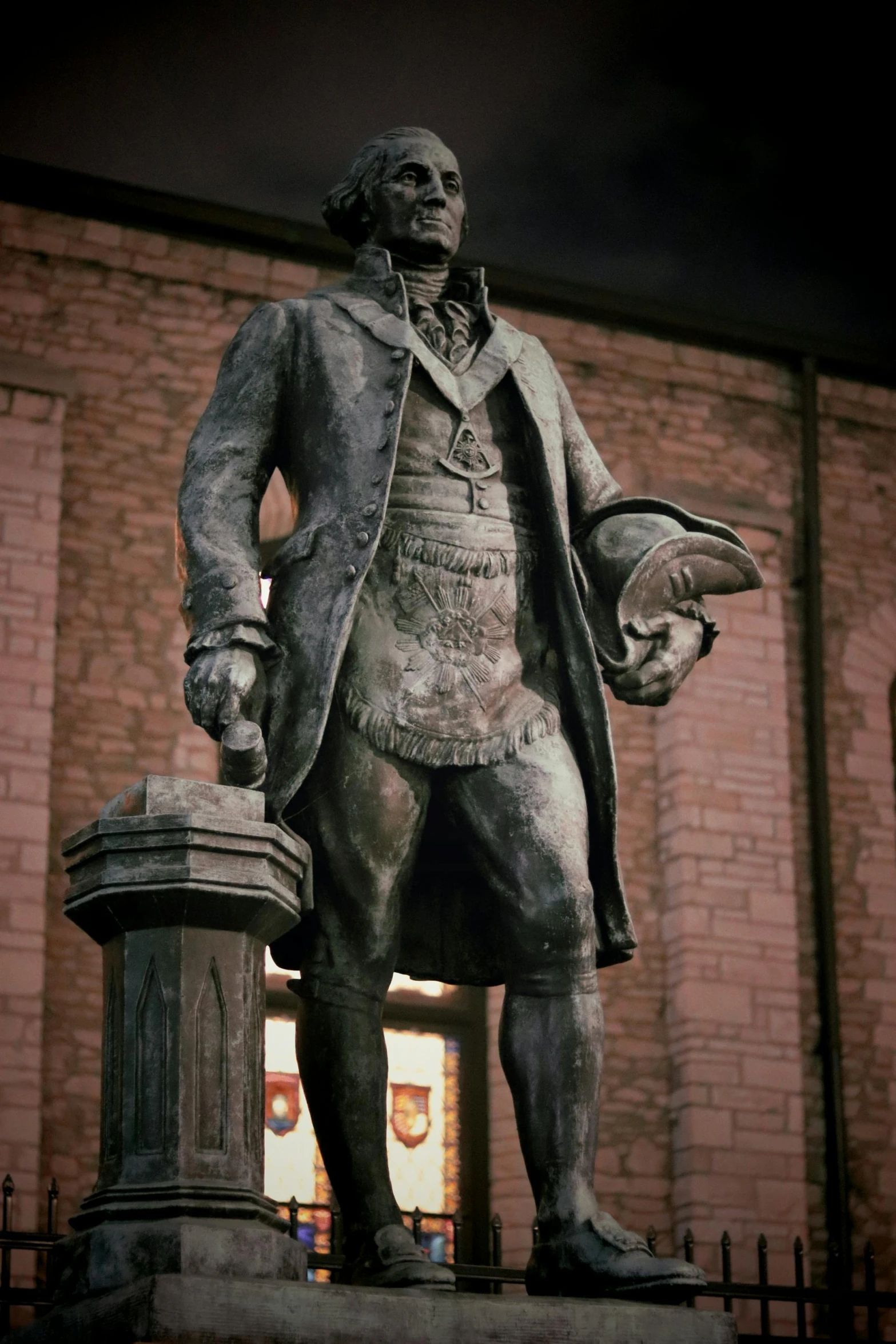 an ornate bronze statue standing next to a brick building