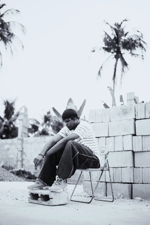 a man with a black hat sitting on a chair