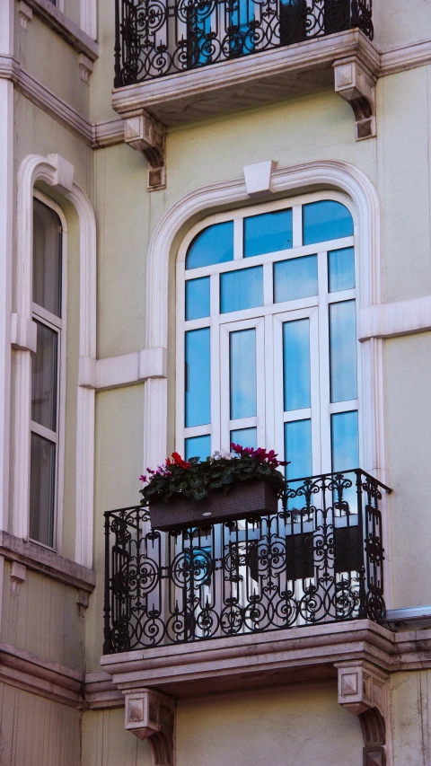 the balcony of a building has flowers and potted plants