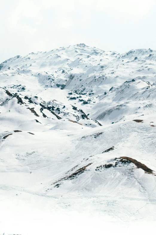 a person skis on a snowy hill with mountains in the background