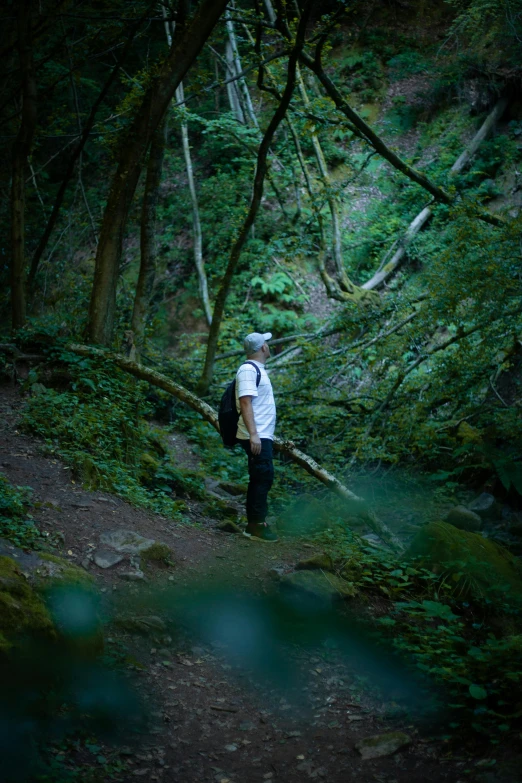 the man with his hat on and backpack is walking up the trail