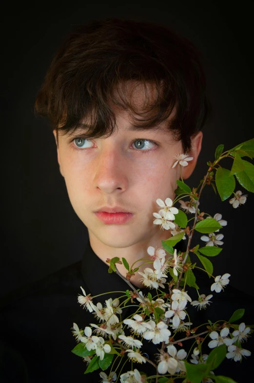 a boy posing for a pograph with flowers