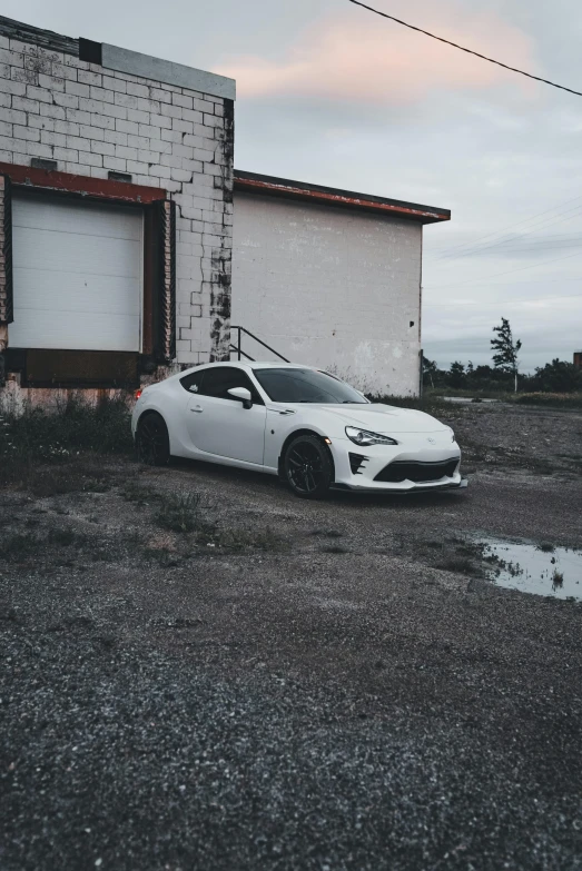 a car parked in front of a building with two garages