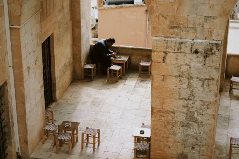 a person is sitting at a table on a balcony