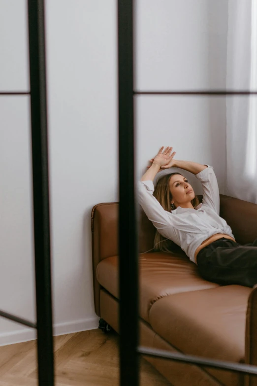 a woman is posing on the couch in her apartment