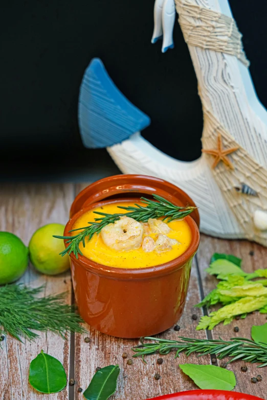 a bowl of soup on a table surrounded by vegetables