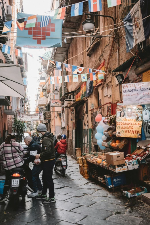 people are walking through a street with tents above them