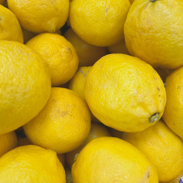 a large pile of yellow lemons on display