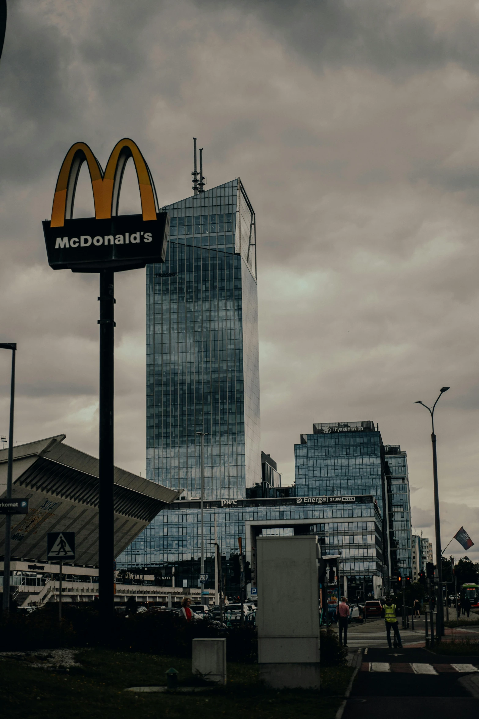 a cloudy sky with buildings and street lights in front of it