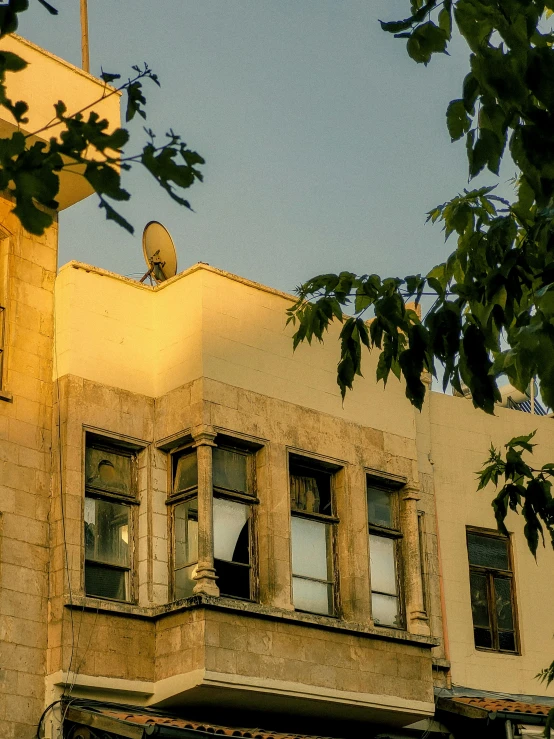 a very tall building with many windows near trees