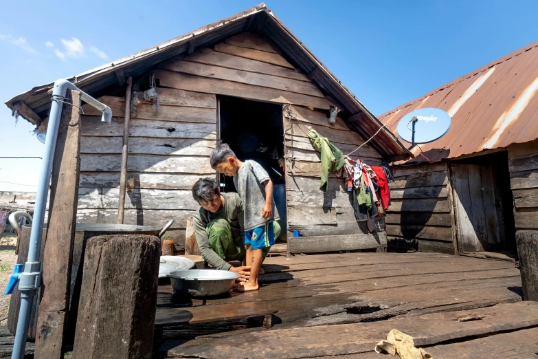 two men hanging out their clothes on a line to dry clothes