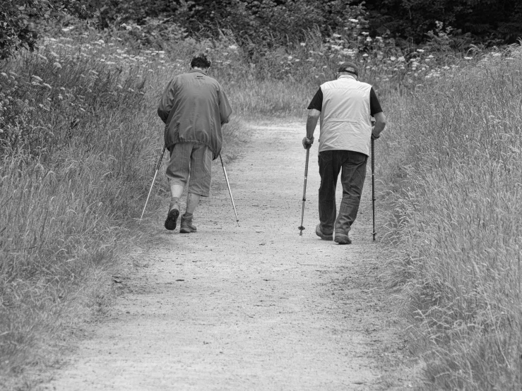 two men walking down the road in their crutches