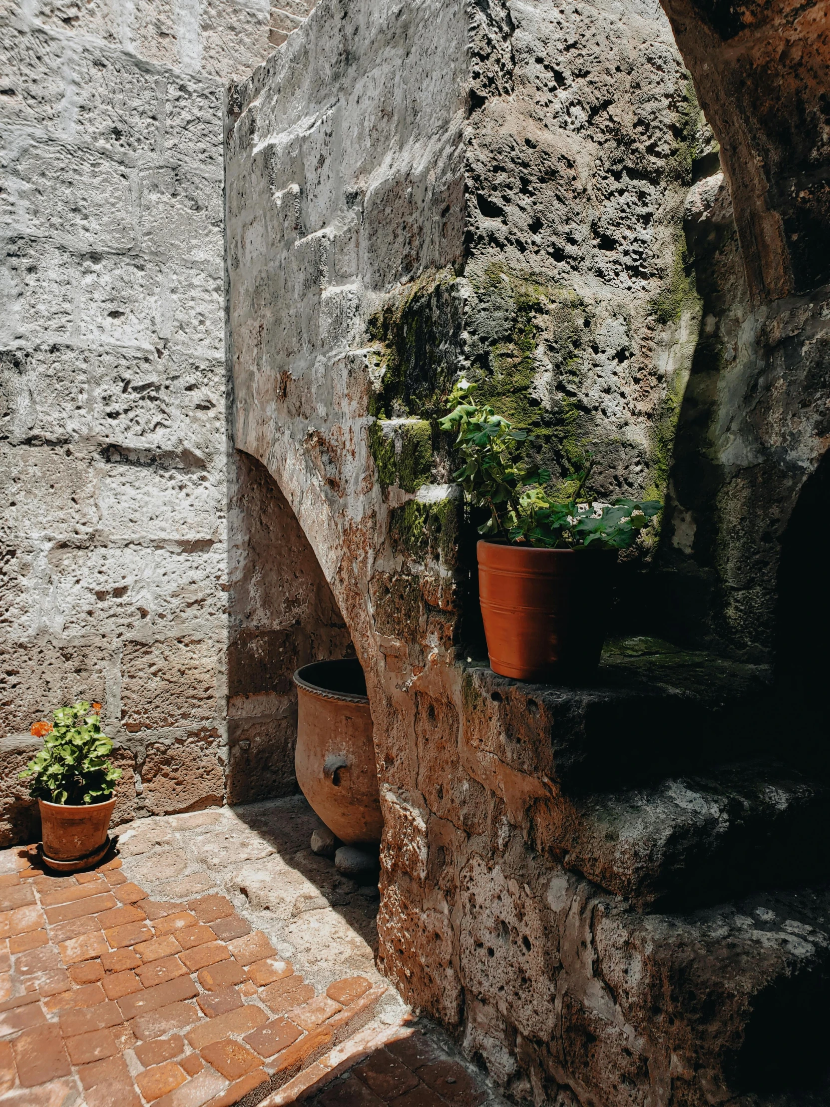 a stone wall and a planter on the corner of a building