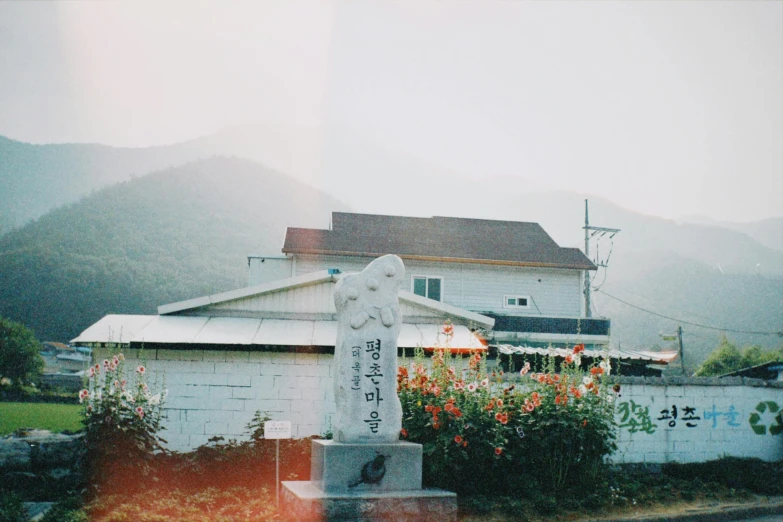 a very old house with flowers and a monument in front of it