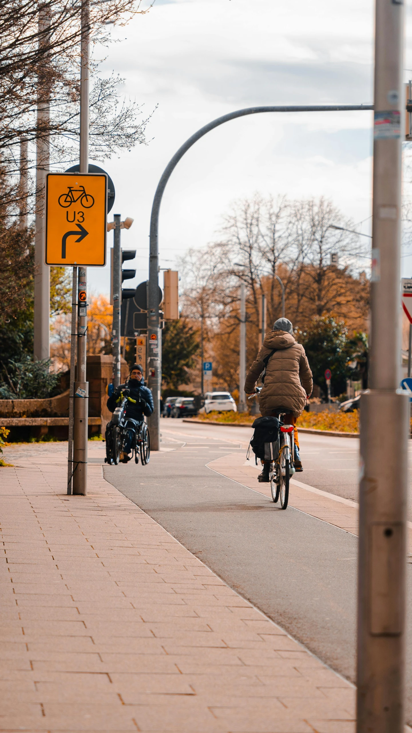 two people riding bicycles down the sidewalk