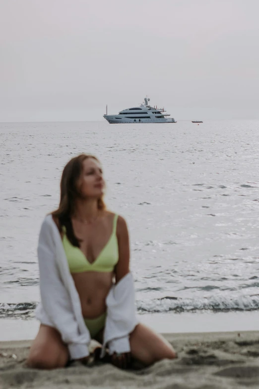 a woman sitting in front of a boat on the ocean