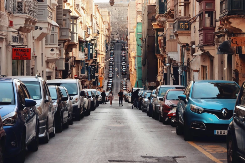 the cars are parked on the street between the buildings