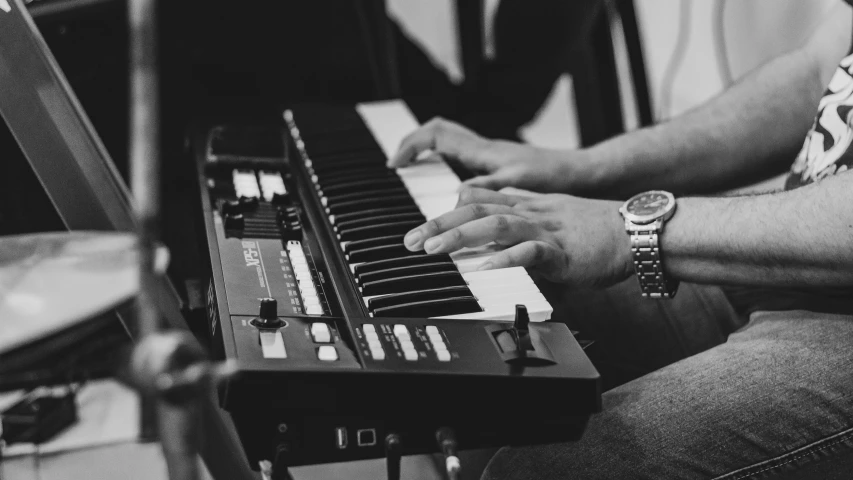 people play electronic piano on stage with music equipment