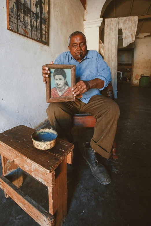 a man holding a picture of a smiling woman