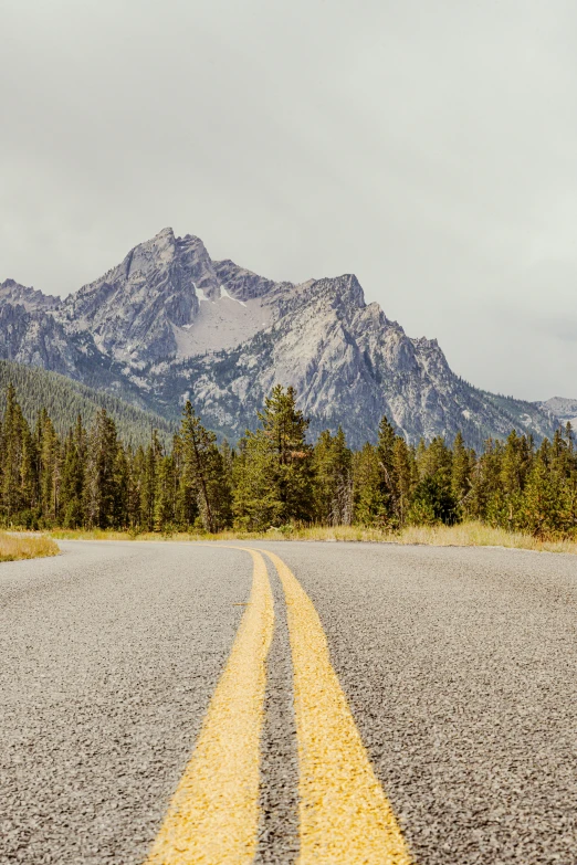 a paved road stretches into a mountain range