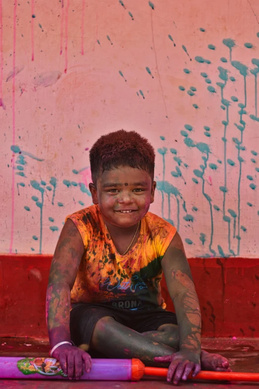 small girl sits with her purple painted body and face