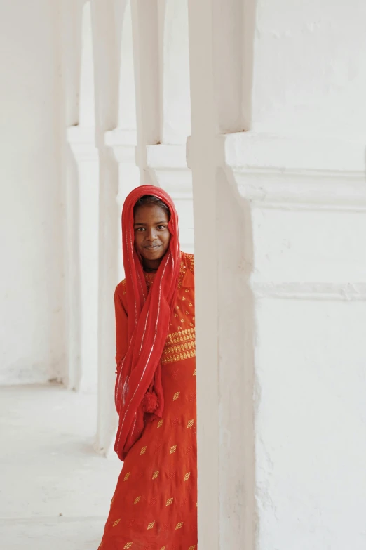 a girl in red stands smiling while wearing a red outfit