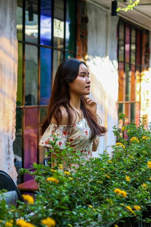 the woman is posing with flowers in front of her