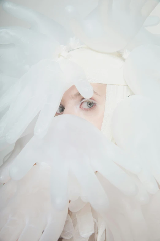 a woman is hiding her face behind the feathers