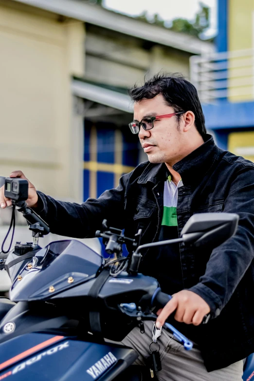 a man standing next to his motorcycle near a building