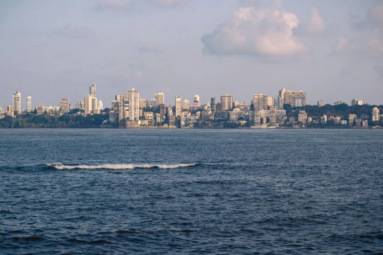 a boat is floating across the water by a large city