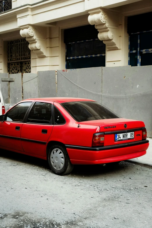 the car is parked in front of the wall of a building