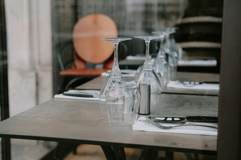 wine glasses and a plate on the table in front of window