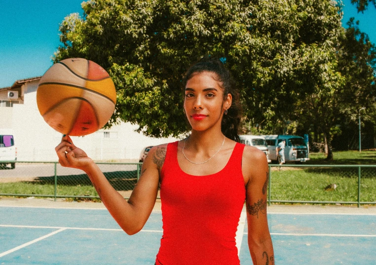 a woman standing on a basketball court holding a basketball