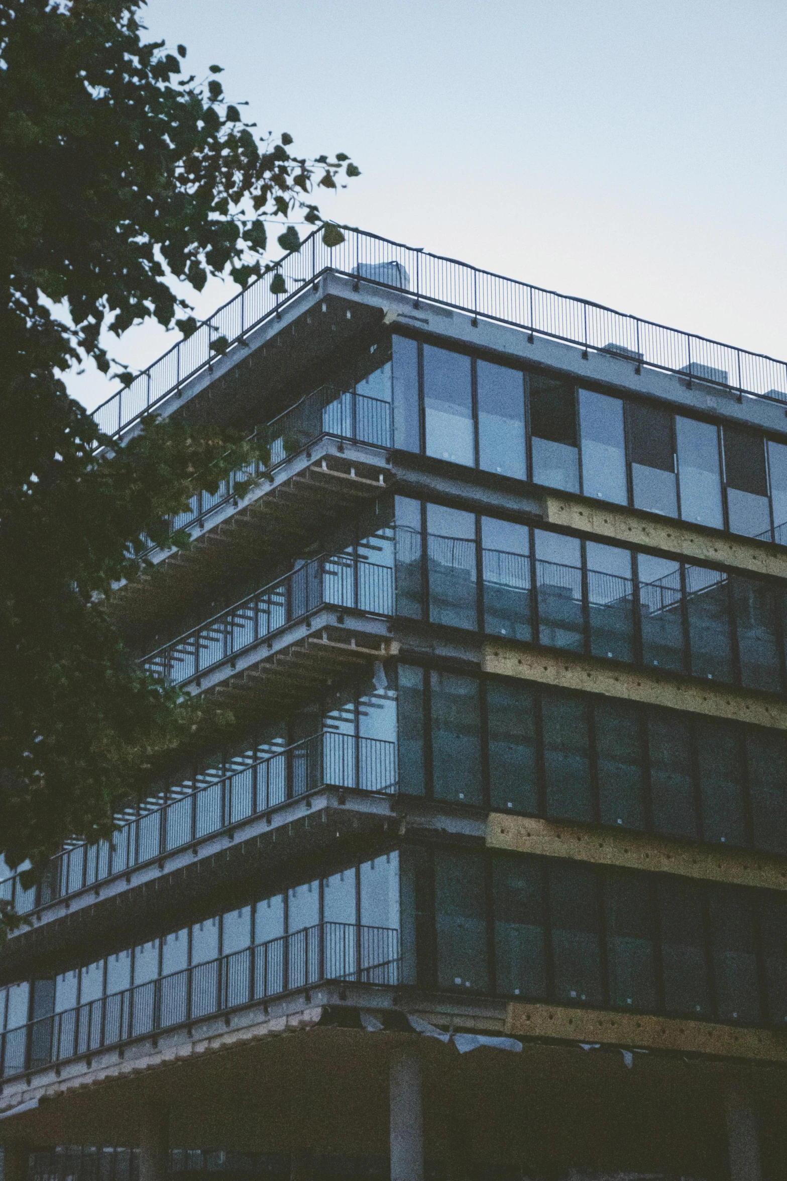 the side of a tall building with many balconies on top