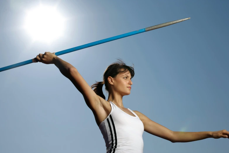 a female jumping with a long pole and two hands holding up the pole