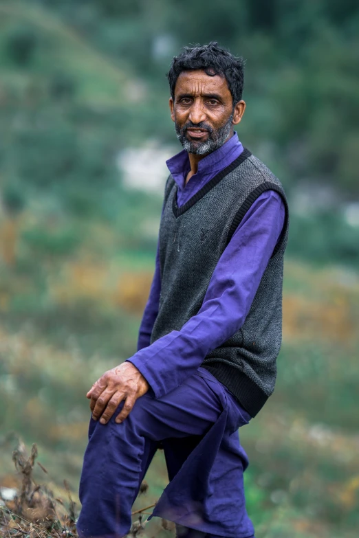 a man sitting on top of a lush green field