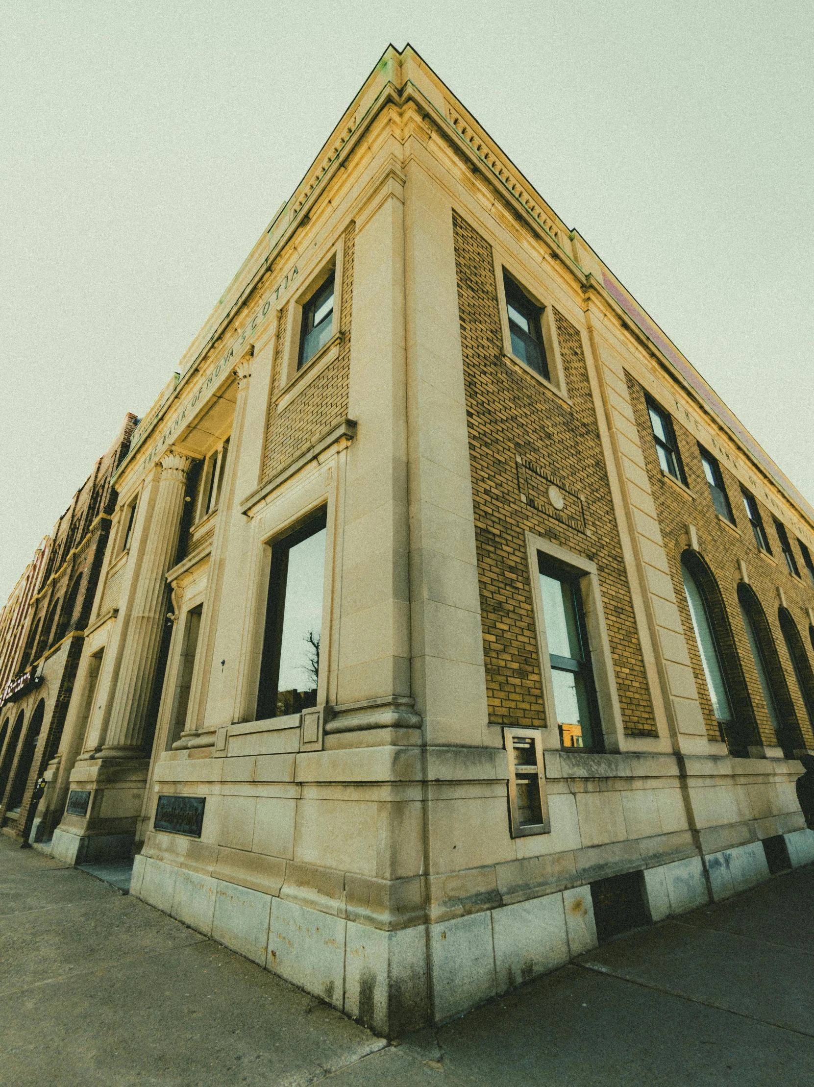 a large beige building with windows and a clock at the top