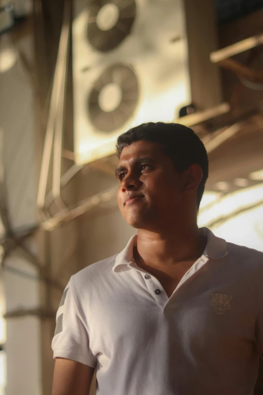 a man in white shirt standing under some lights