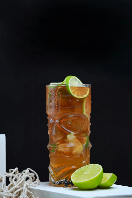 a drink in a glass with limes and ice